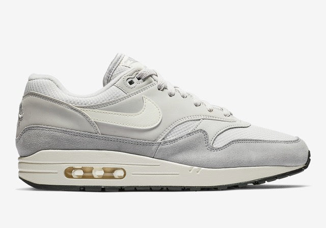 Nike Air Max 1 Vast Grey grise avec empiècements en suède et cuir, touches Spruce Aura et Ridgerock et unité Air visible vue de profil. 