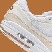 Vue zoomée sur les détails arrières de la Nike Air Max 1 SC Sail en textile blanc et cuir synthétique écru avec mudguard Coconut Milk et unité Air Max visible.