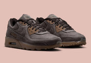Nike Air Max 90 Shadow Brown, sneaker Nike marron avec empeigne multi-matières, Swoosh latéral et unité Air visible au talon.
