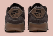 Nike Air Max 90 Shadow Brown, sneaker Nike marron avec empeigne multi-matières, Swoosh latéral et unité Air visible au talon.