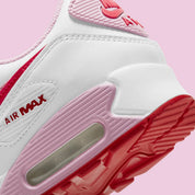 Nike Air Max 90 Valentine's Day 2021 avec tige en cuir et mesh aux tons clairs et roses, unité Max Air visible au talon et semelle extérieure en caoutchouc gaufré.