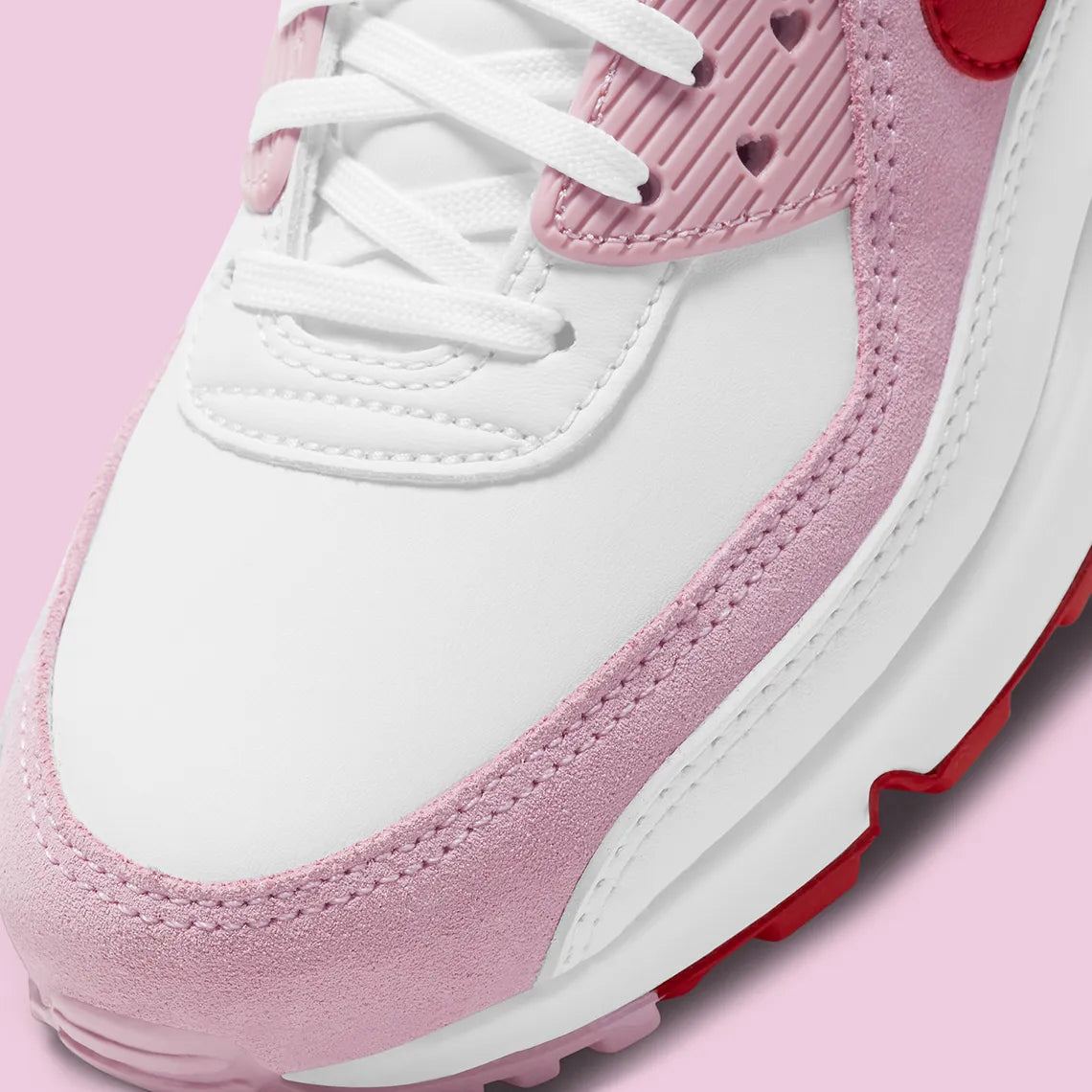 Nike Air Max 90 Valentine's Day 2021 avec tige en cuir et mesh aux tons clairs et roses, unité Max Air visible au talon et semelle extérieure en caoutchouc gaufré.