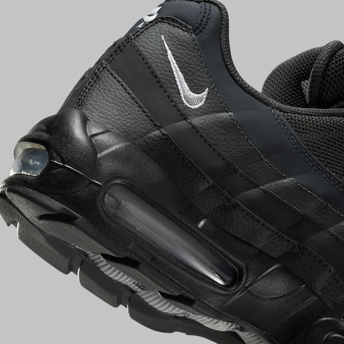 Vue zoomée sur les détails arrières de la Nike Air Max 95 Black Silver noire et grise avec panneaux superposés Black, Anthracite et Stadium Grey et unités Nike Air visibles.