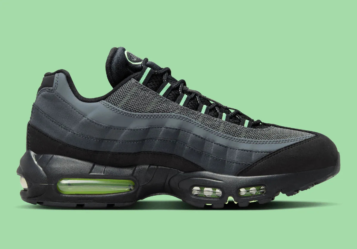 Nike Air Max 95 Vapor Green noire et grise avec panneaux superposés, détails vert Vapor Green et unités Nike Air visibles.