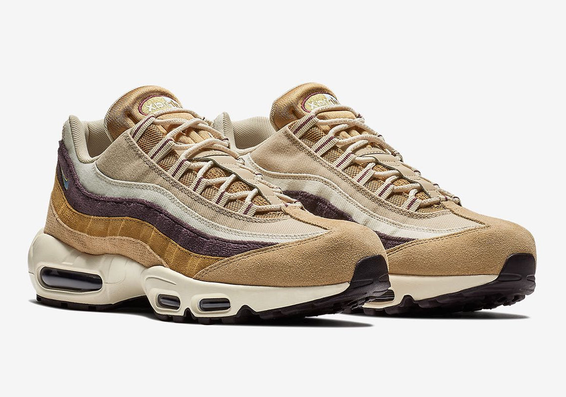Nike Air Max 95 Desert beige et kaki avec panneaux en canvas et daim, détails bleu Royal Tint et unités Air visibles.