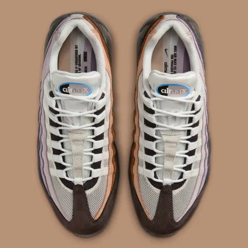 Nike Air Max 95 Unearthed beige et marron avec panneaux multicouches Summit White, Cacao Wow et Velvet Brown et unités Air bleues visibles.