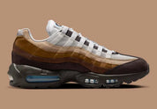 Nike Air Max 95 Unearthed beige et marron avec panneaux multicouches Summit White, Cacao Wow et Velvet Brown et unités Air bleues visibles.