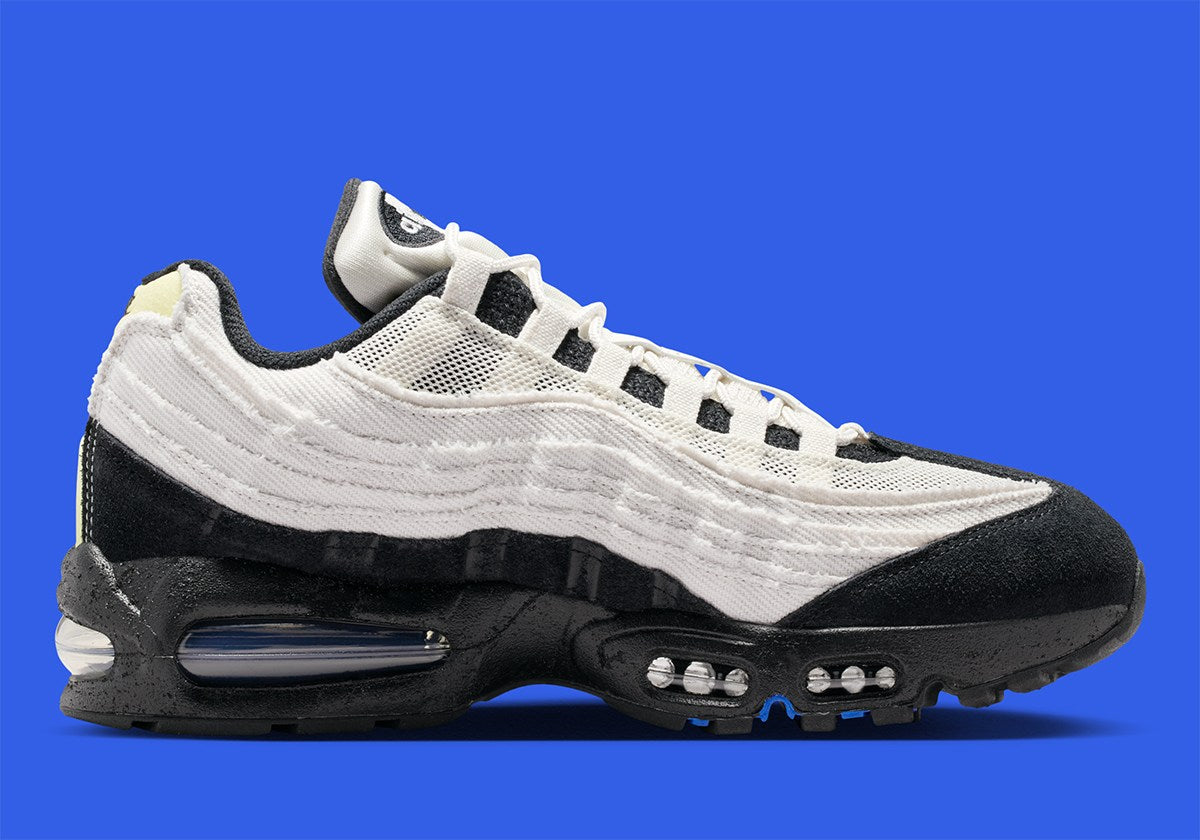 Nike Air Max 95 Big Bubble City Pack Paris Atelier, sneaker en toile claire à bords bruts avec détails Racer Blue et unités Max Air visibles.