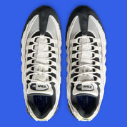 Nike Air Max 95 Big Bubble City Pack Paris Atelier, sneaker en toile claire à bords bruts avec détails Racer Blue et unités Max Air visibles.