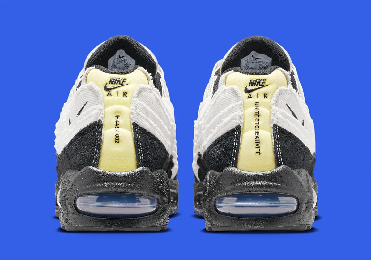 Nike Air Max 95 Big Bubble City Pack Paris Atelier, sneaker en toile claire à bords bruts avec détails Racer Blue et unités Max Air visibles.