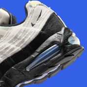 Nike Air Max 95 Big Bubble City Pack Paris Atelier, sneaker en toile claire à bords bruts avec détails Racer Blue et unités Max Air visibles.
