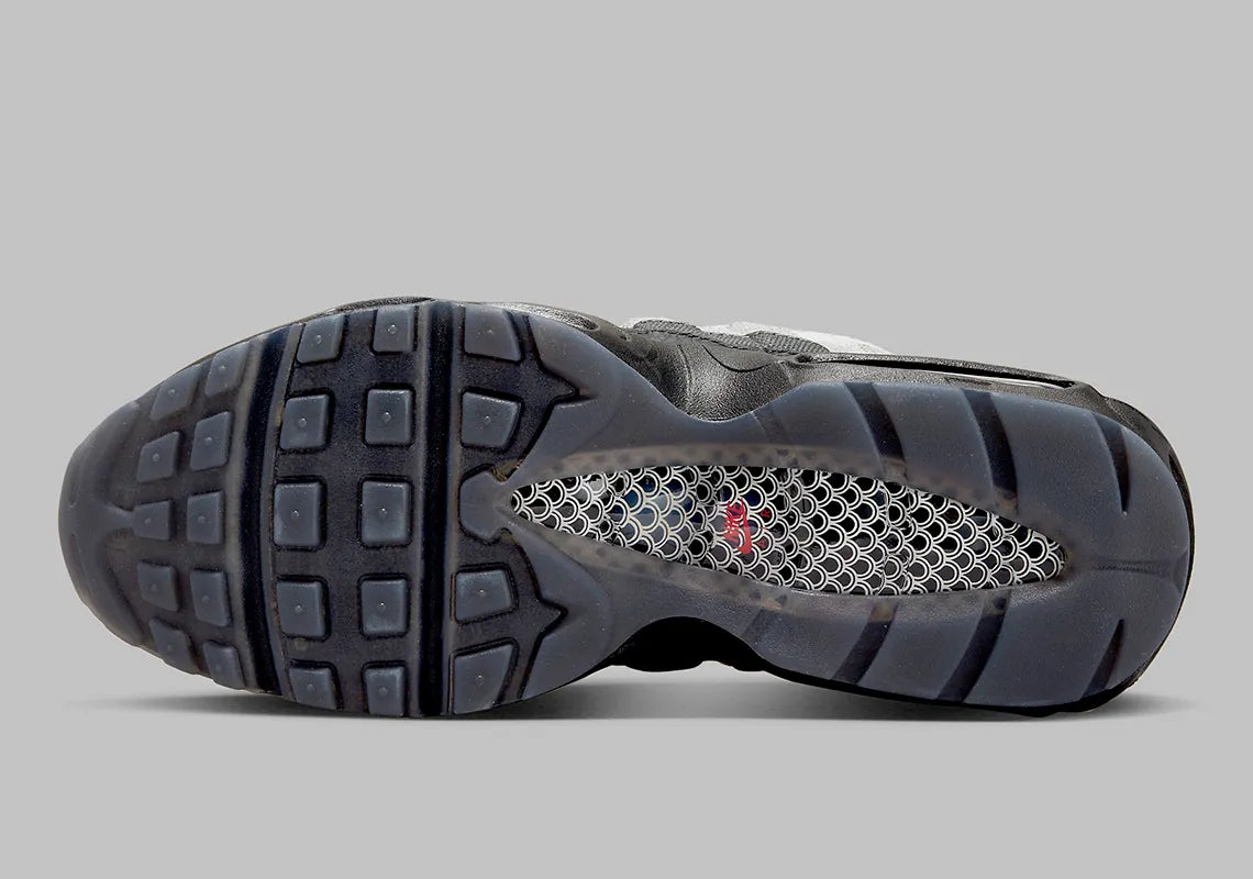 Nike Air Max 95 Fish Scales grise, noire et blanche avec motif écailles au talon, empiècements texturés et unités Air visibles.