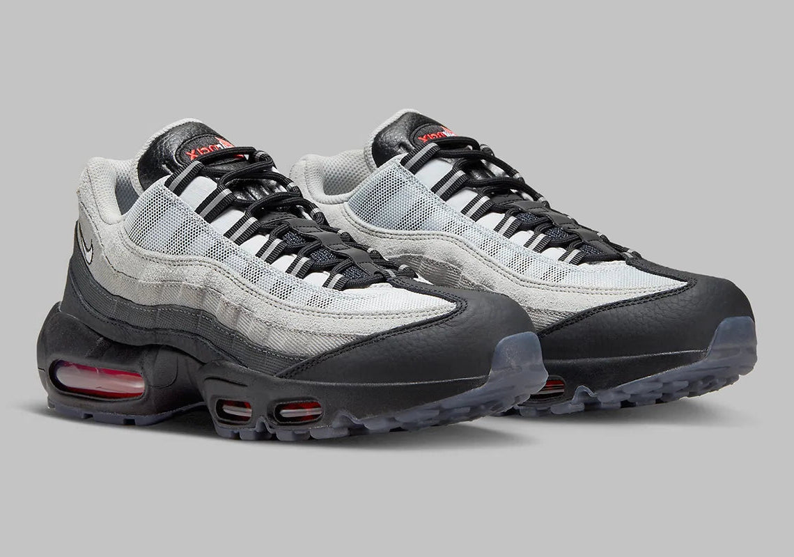 Nike Air Max 95 Fish Scales grise, noire et blanche avec motif écailles au talon, empiècements texturés et unités Air visibles.