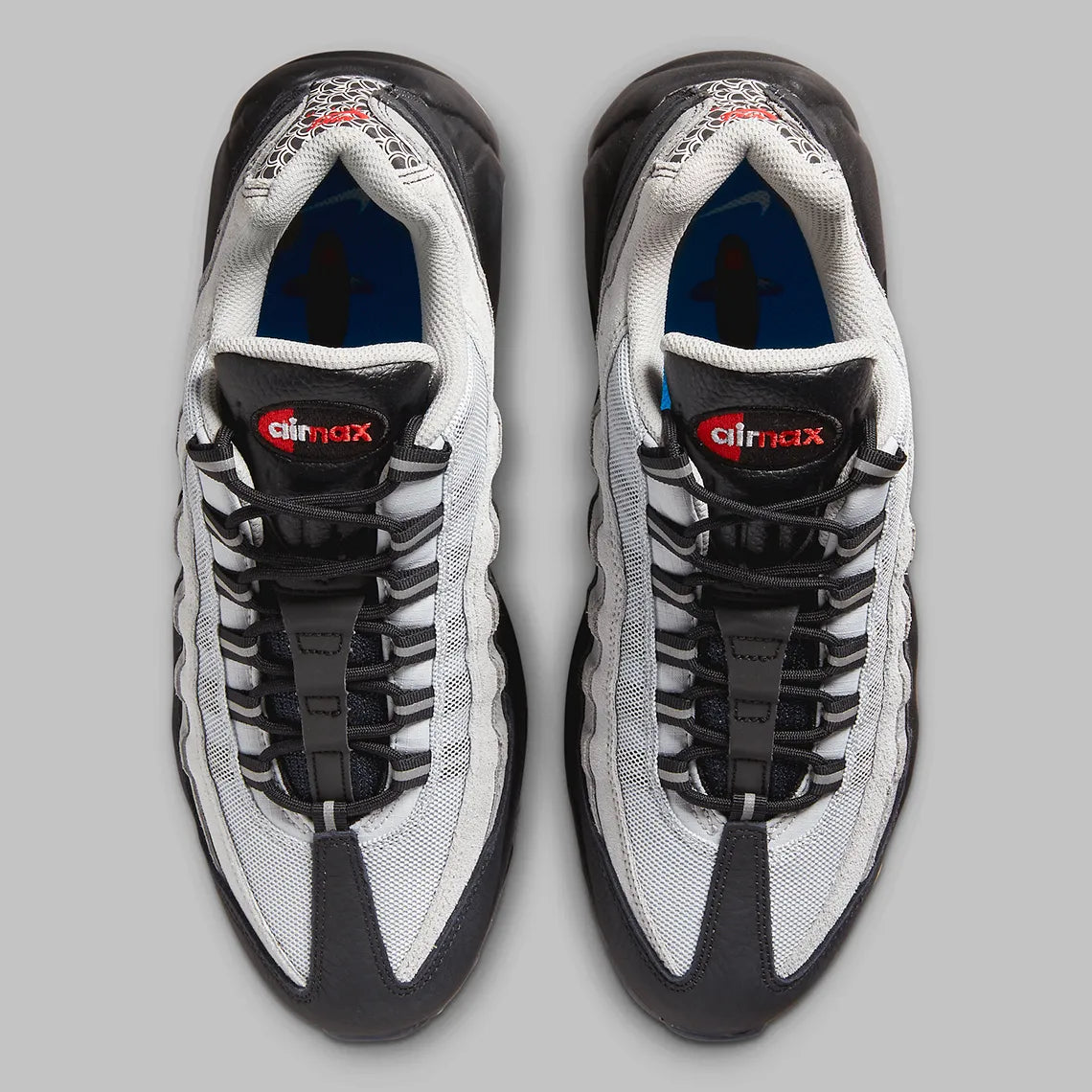 Nike Air Max 95 Fish Scales grise, noire et blanche avec motif écailles au talon, empiècements texturés et unités Air visibles.