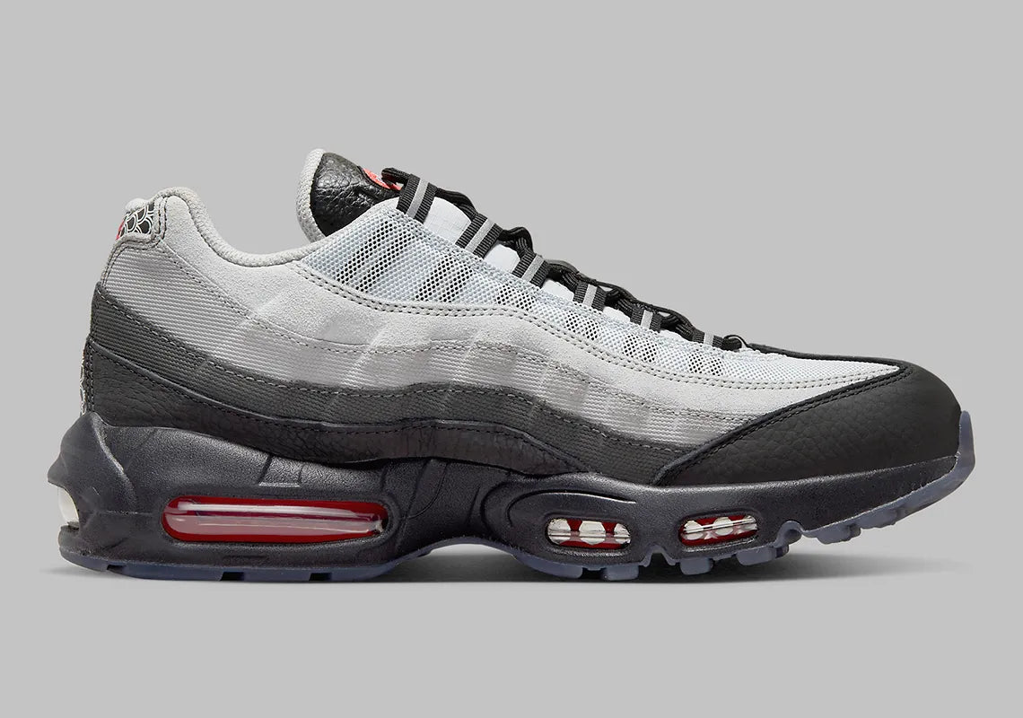 Nike Air Max 95 Fish Scales grise, noire et blanche avec motif écailles au talon, empiècements texturés et unités Air visibles.