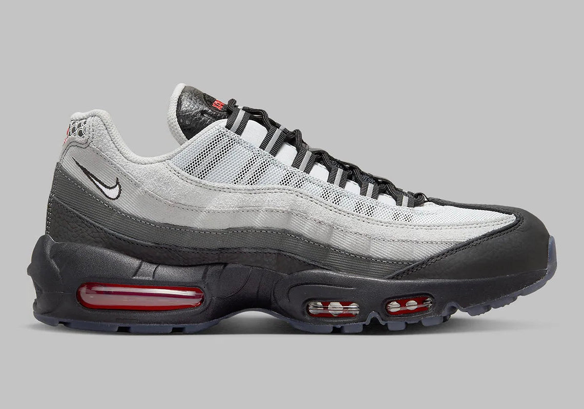 Nike Air Max 95 Fish Scales grise, noire et blanche avec motif écailles au talon, empiècements texturés et unités Air visibles.