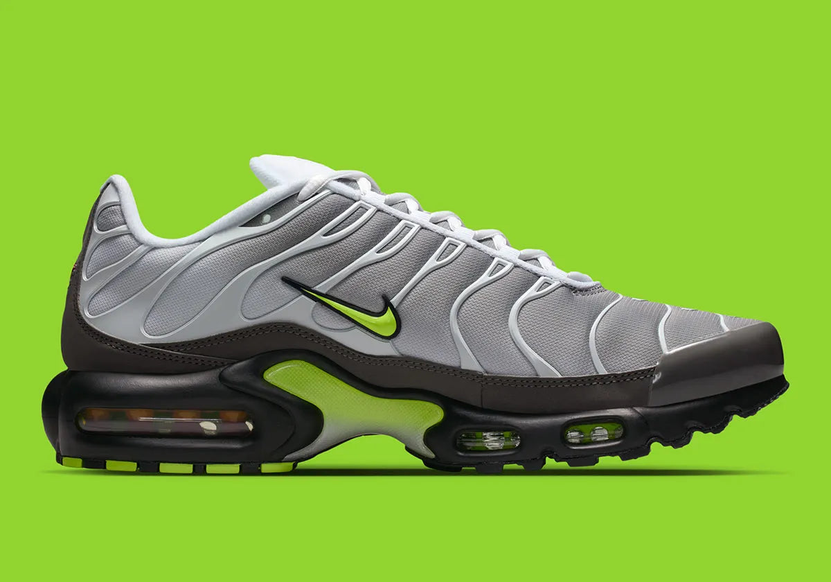 Nike Air Max Plus Neon grise et noire avec mesh dégradé, détails Neon Yellow fluorescents et unités Tuned Air visibles.