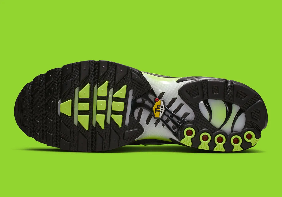 Nike Air Max Plus Neon grise et noire avec mesh dégradé, détails Neon Yellow fluorescents et unités Tuned Air visibles.