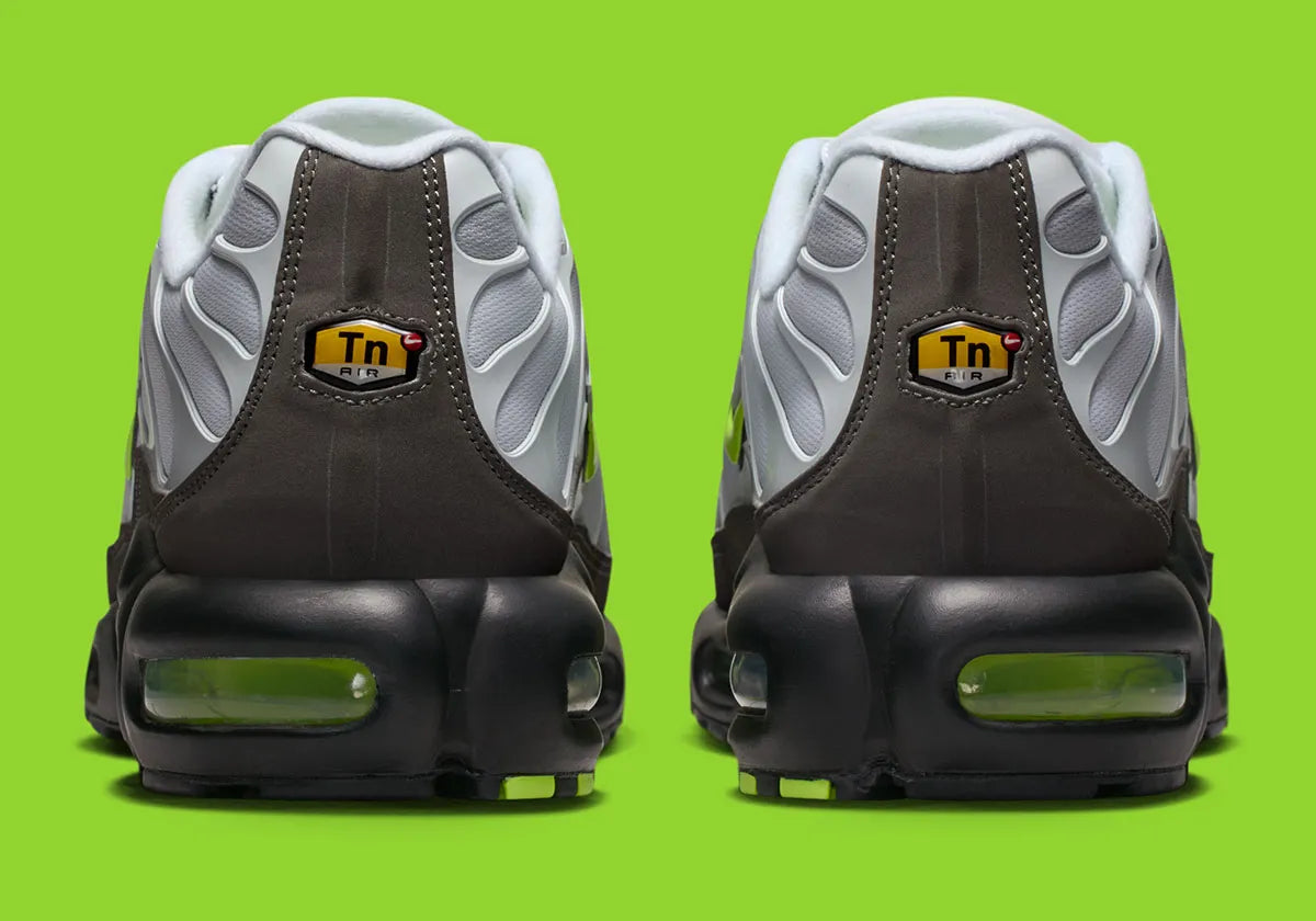 Nike Air Max Plus Neon grise et noire avec mesh dégradé, détails Neon Yellow fluorescents et unités Tuned Air visibles.