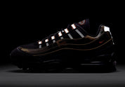 Sneakers Nike Air Max 95 Safety Orange Camo en matériaux premium avec motif camouflage, accents orange et unités Air visibles vue de nuit pour faire ressortir le côté réfléchissant de la paire. 