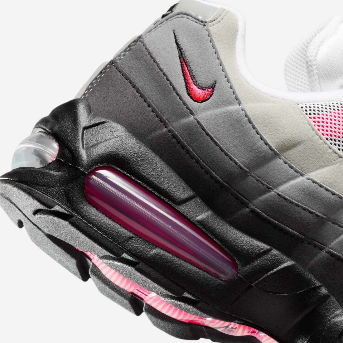 Vue zoomée sur les détails arrières de la Nike Air Max 95 OG Big Bubble Reverse Solar Red avec tige en mesh, cuir synthétique et suède en dégradé de gris, accents Solar Red, unités Big Bubble Air visibles et semelle extérieure en caoutchouc.