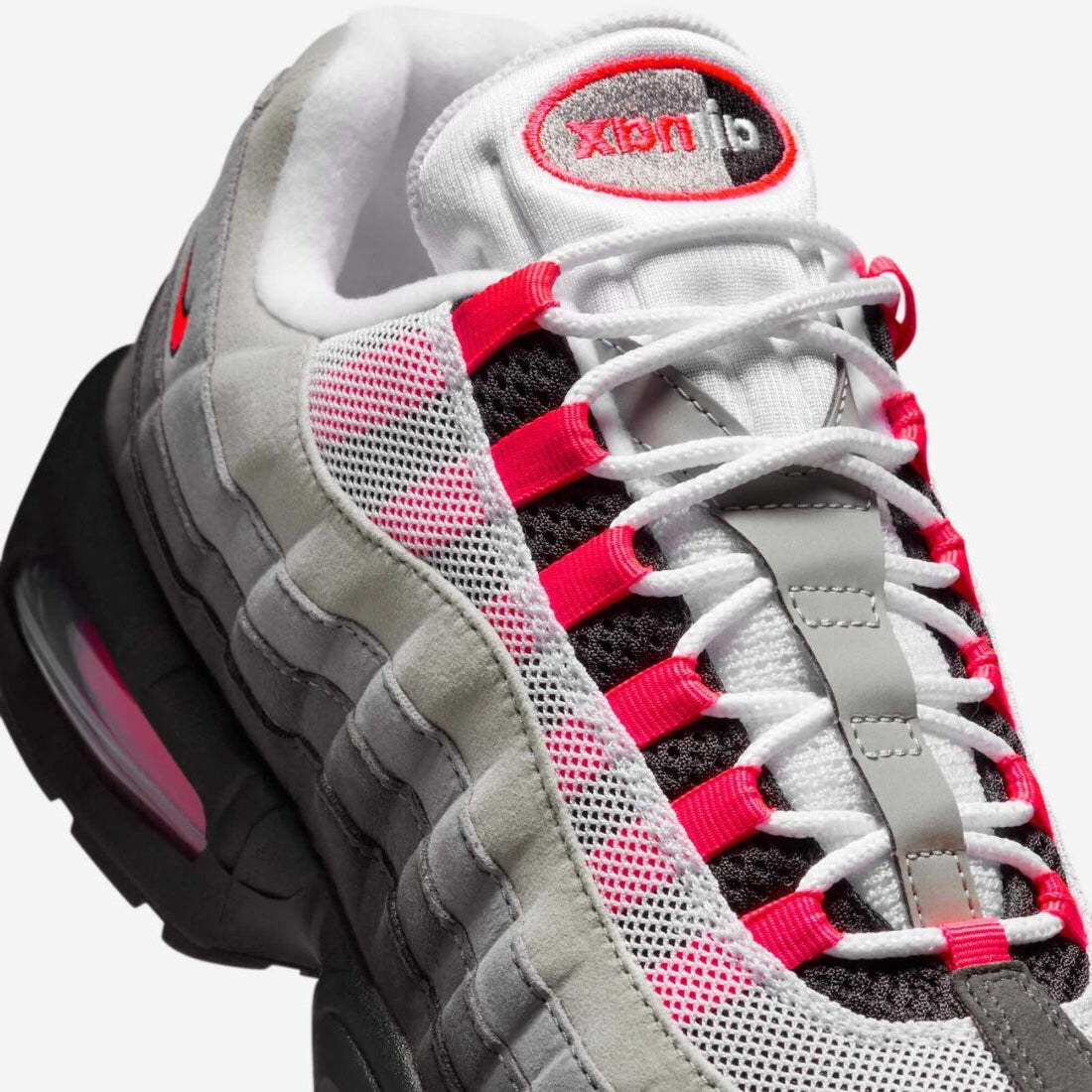 Vue zoomée sur les détails latéraux de la Nike Air Max 95 OG Big Bubble Reverse Solar Red avec tige en mesh, cuir synthétique et suède en dégradé de gris, accents Solar Red, unités Big Bubble Air visibles et semelle extérieure en caoutchouc.