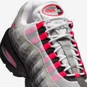 Vue zoomée sur les détails latéraux de la Nike Air Max 95 OG Big Bubble Reverse Solar Red avec tige en mesh, cuir synthétique et suède en dégradé de gris, accents Solar Red, unités Big Bubble Air visibles et semelle extérieure en caoutchouc.