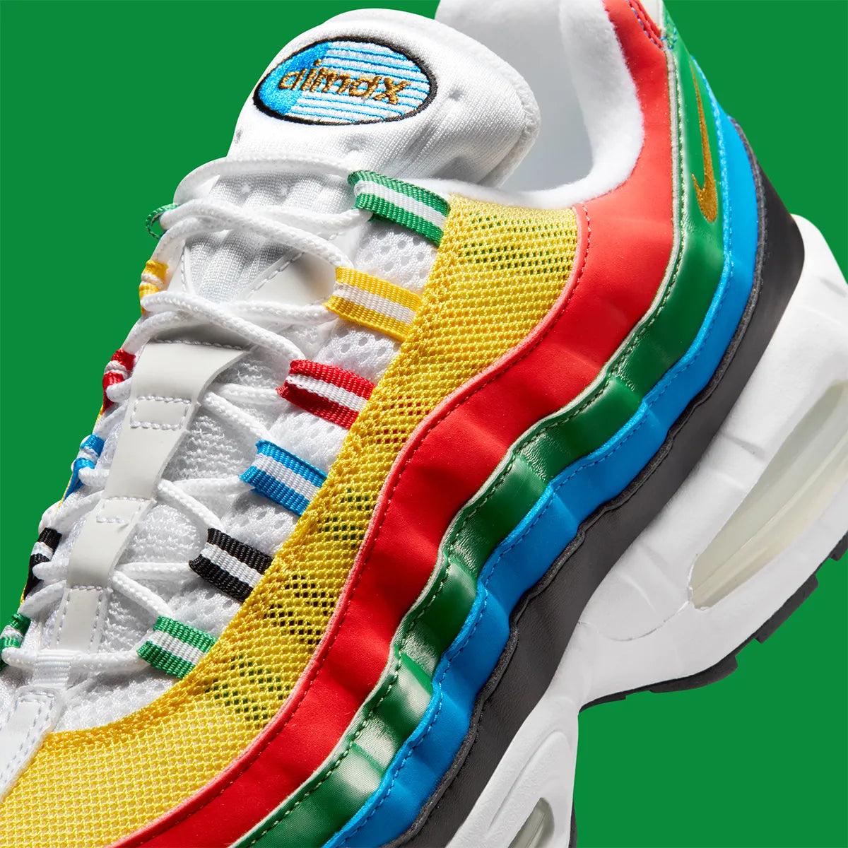 Nike Air Max 95 Olympic 2026 avec tige en mesh, cuir synthétique et suède blanc et bleu, détails Metallic Gold, unités Max Air visibles et semelle extérieure en caoutchouc vue de profil. 