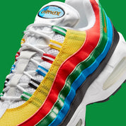 Nike Air Max 95 Olympic 2026 avec tige en mesh, cuir synthétique et suède blanc et bleu, détails Metallic Gold, unités Max Air visibles et semelle extérieure en caoutchouc vue de profil. 