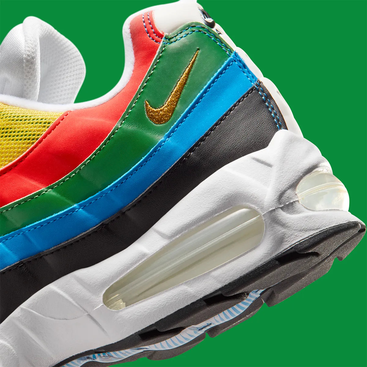 Nike Air Max 95 Olympic 2026 avec tige en mesh, cuir synthétique et suède blanc et bleu, détails Metallic Gold, unités Max Air visibles et semelle extérieure en caoutchouc vue de profil. 