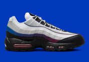 Nike Air Max 95 Toronto blanche, grise, rouge et bleue avec panneaux multicouches, Swoosh rouge et unités Max Air visibles.