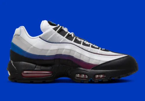 Nike Air Max 95 Toronto blanche, grise, rouge et bleue avec panneaux multicouches, Swoosh rouge et unités Max Air visibles.