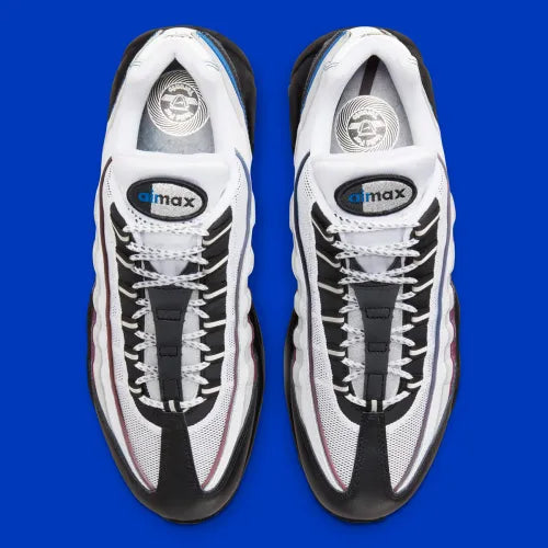 Nike Air Max 95 Toronto blanche, grise, rouge et bleue avec panneaux multicouches, Swoosh rouge et unités Max Air visibles.