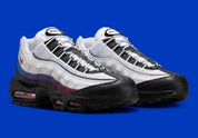 Nike Air Max 95 Toronto blanche, grise, rouge et bleue avec panneaux multicouches, Swoosh rouge et unités Max Air visibles.