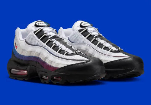Nike Air Max 95 Toronto blanche, grise, rouge et bleue avec panneaux multicouches, Swoosh rouge et unités Max Air visibles.