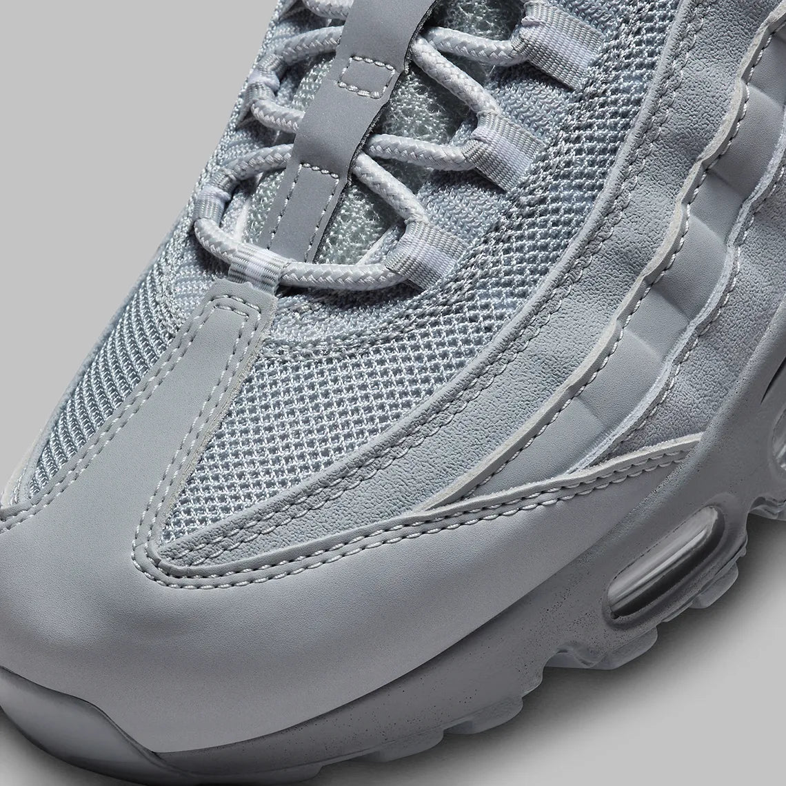 Nike Air Max 95 Wolf Grey FJ4217-001, sneaker grise Wolf Grey et Cool Grey avec panneaux ondulés et unités Nike Air visibles.