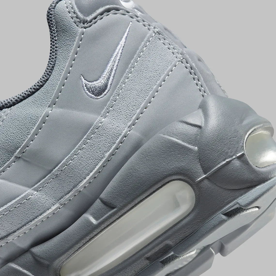 Nike Air Max 95 Wolf Grey FJ4217-001, sneaker grise Wolf Grey et Cool Grey avec panneaux ondulés et unités Nike Air visibles.