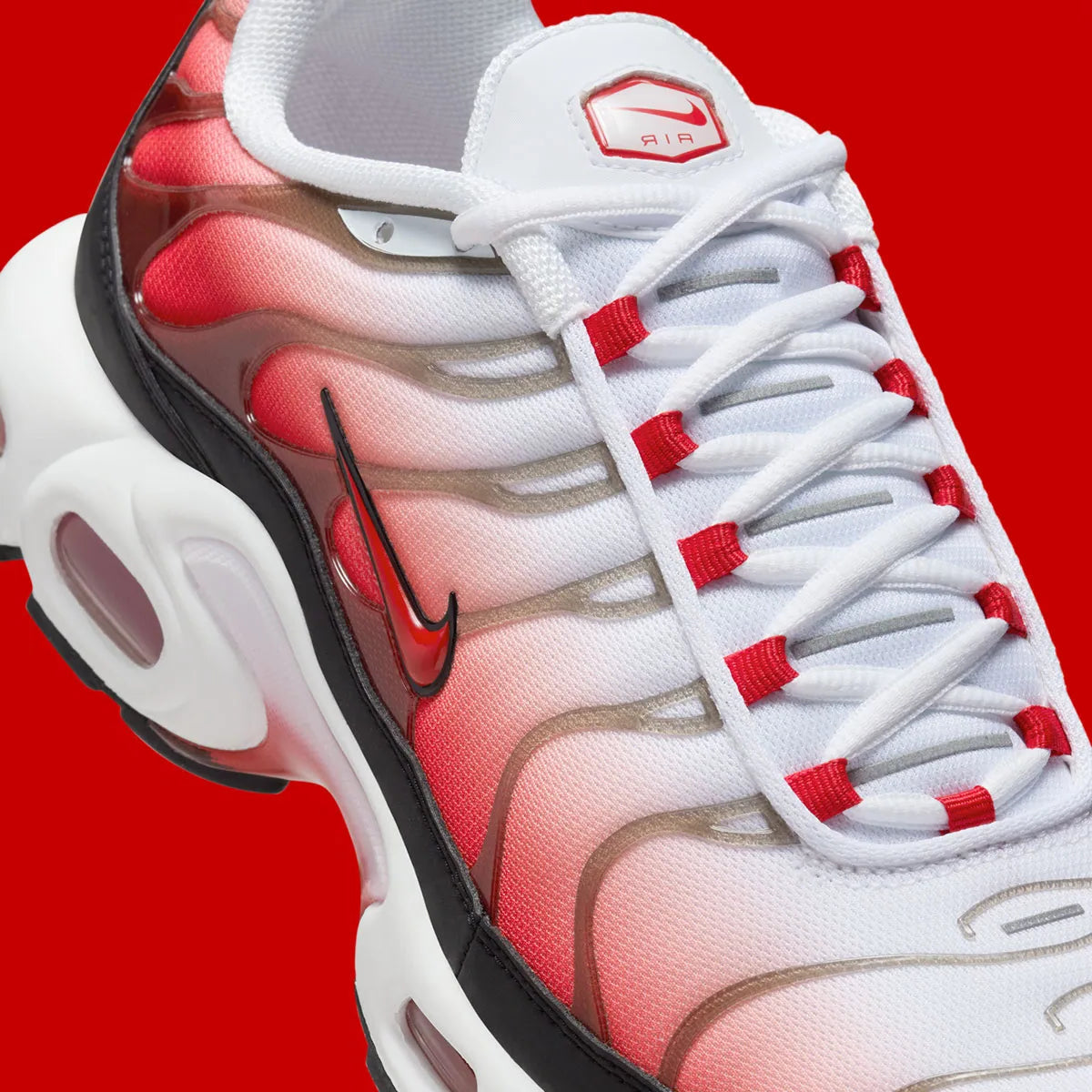 Vue zoomée sur les détails latéraux de la Nike Air Max Plus White Black University Red blanche et rouge avec dégradé sur mesh, cage TPU, détails noirs et amorti Tuned Air visible.
