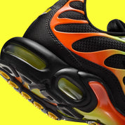 Vue zoomée sur les détails arrières de la Nike Air Max Plus Sunrise noire avec cage dégradée jaune fluorescent et orange, tige en mesh et unités Nike Air visibles.