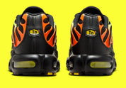 Nike Air Max Plus Sunrise noire avec cage dégradée jaune fluorescent et orange, tige en mesh et unités Nike Air visibles vue de derrière. 