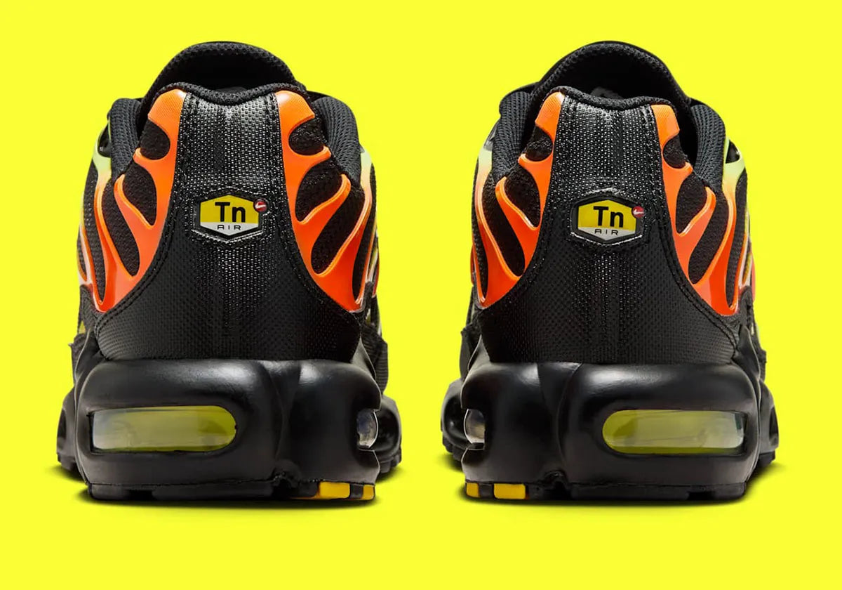 Nike Air Max Plus Sunrise noire avec cage dégradée jaune fluorescent et orange, tige en mesh et unités Nike Air visibles vue de derrière. 
