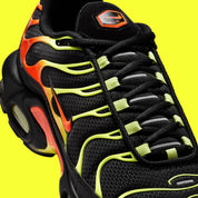 Vue zoomée sur les détails latéraux de la Nike Air Max Plus Sunrise noire avec cage dégradée jaune fluorescent et orange, tige en mesh et unités Nike Air visibles. 