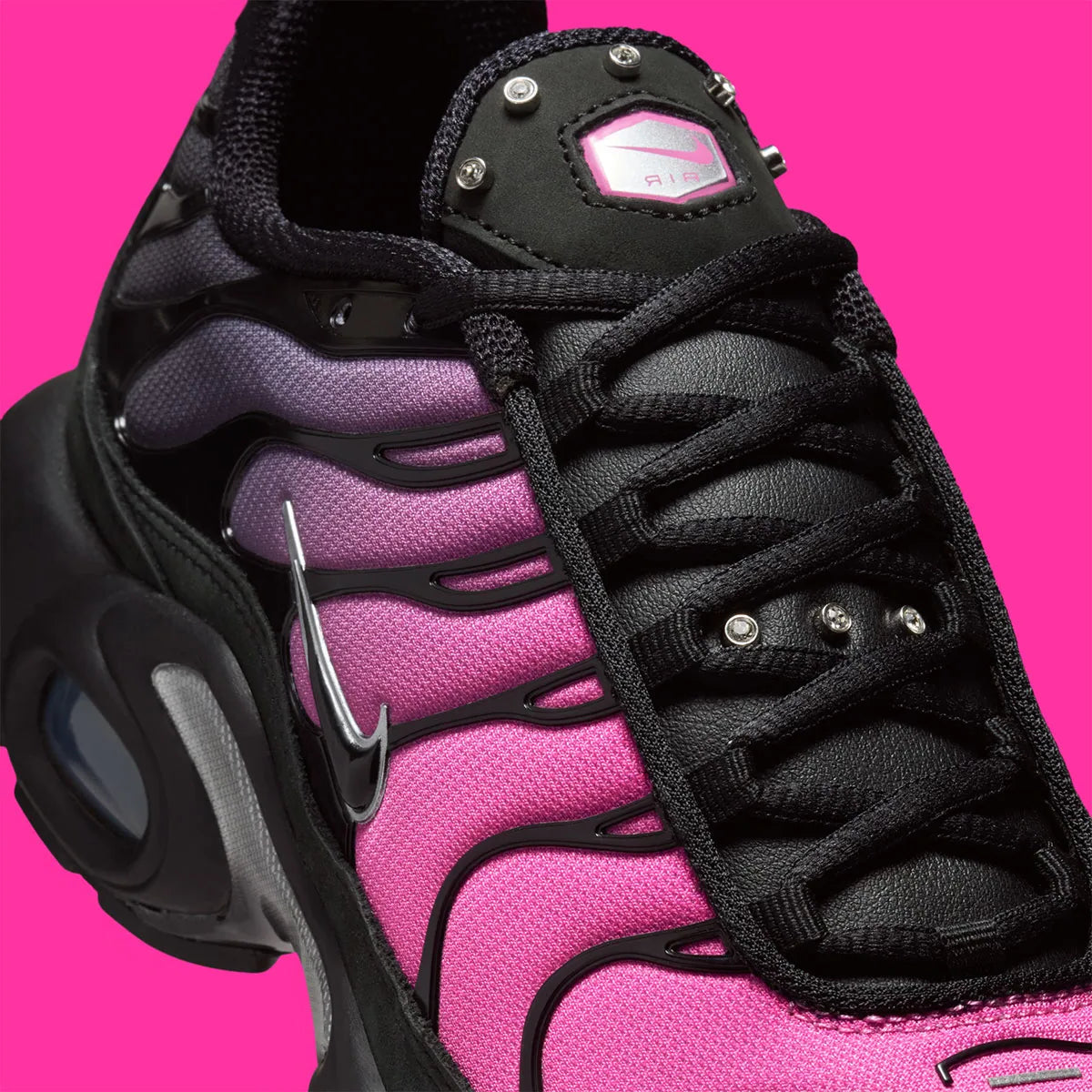 Vue zoomée sur les détails latéraux de la Nike Air Max Plus Black Peony noire avec dégradé rose et violet, Swoosh argenté, cage TPU et détails cristallisés sur la languette.