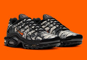 Sneakers Nike Air Max Plus noires camouflage avec accents Safety Orange en mesh technique et amorti Tuned Air visible
