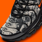 Sneakers Nike Air Max Plus noires camouflage avec accents Safety Orange en mesh technique et amorti Tuned Air visible
