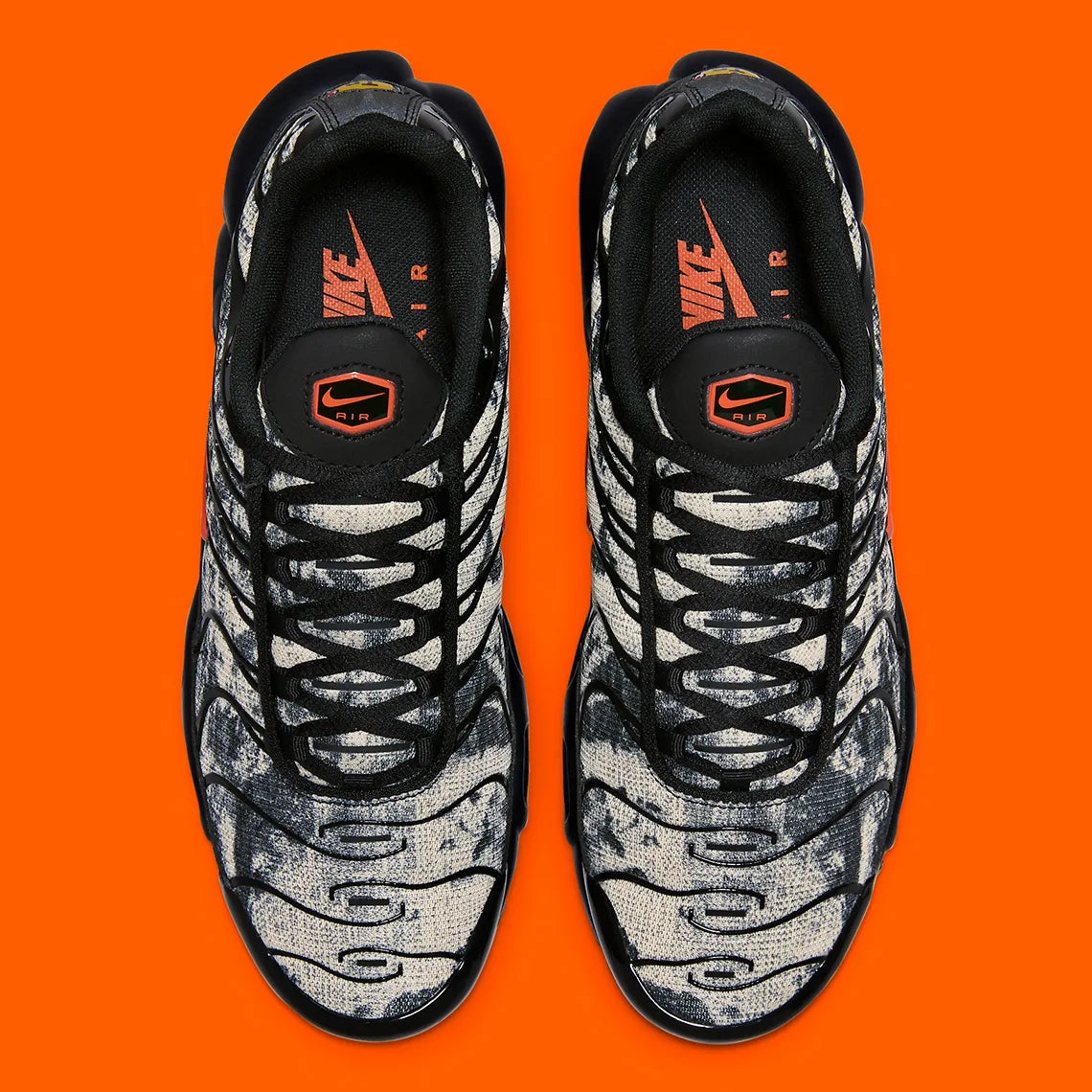 Sneakers Nike Air Max Plus noires camouflage avec accents Safety Orange en mesh technique et amorti Tuned Air visible
