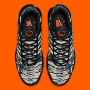 Sneakers Nike Air Max Plus noires camouflage avec accents Safety Orange en mesh technique et amorti Tuned Air visible
