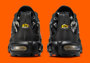 Sneakers Nike Air Max Plus noires camouflage avec accents Safety Orange en mesh technique et amorti Tuned Air visible
