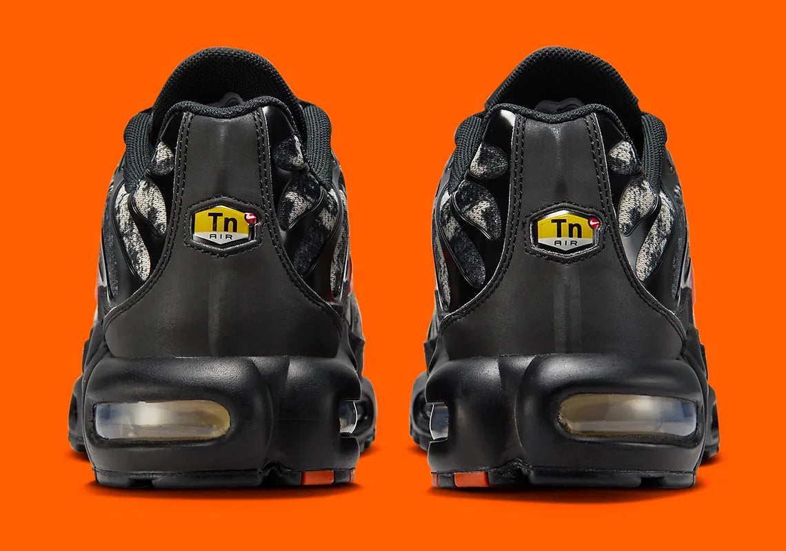 Sneakers Nike Air Max Plus noires camouflage avec accents Safety Orange en mesh technique et amorti Tuned Air visible
