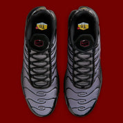 Nike Air Max Plus Black Pencil Point Team Crimson noire avec détails rouges Team Crimson, renforts ondulés et unités Air visibles.